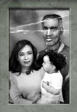 A black and white family portrait. Left is Azian, holding a baby Alyx on her left, placing her in the right of the image. Eli stands above and behind Alyx.